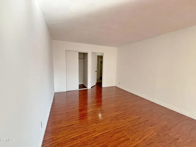 a view of empty room with wooden floor