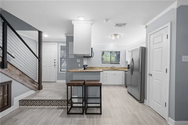 a kitchen with a refrigerator a sink and cabinets