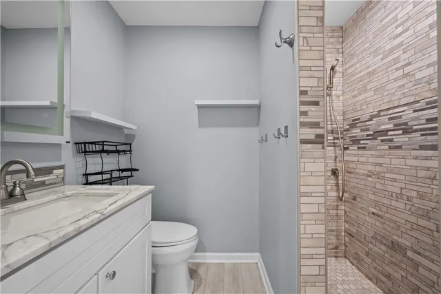 a bathroom with a sink a toilet and shower