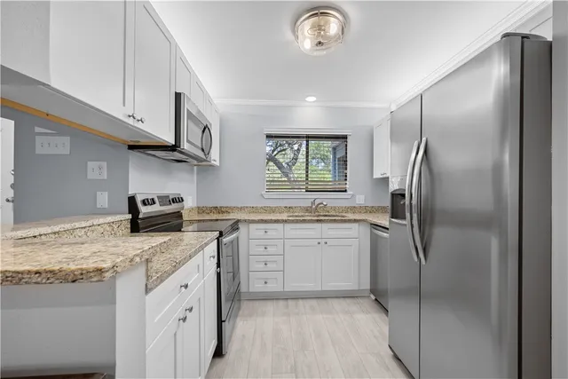 a kitchen with stainless steel appliances granite countertop a refrigerator sink and stove