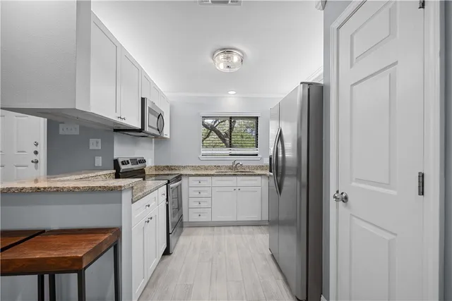 a kitchen with a sink a refrigerator and cabinets