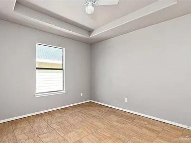 1426 East Rogers Road, Unit 6 Edinburg, TX 78542 - Photo 8 of 13 Spare room featuring a raised ceiling, baseboards, and ceiling fan