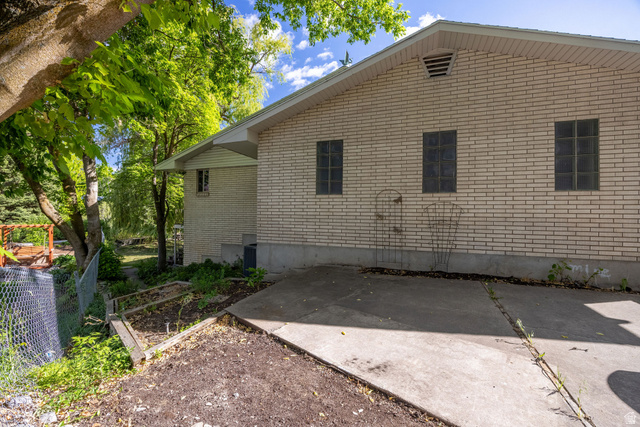 1365 Sumac Drive Logan, UT 84321 - Photo 64 of 66 Light-colored brick exterior with three rectangular windows and a concrete driveway