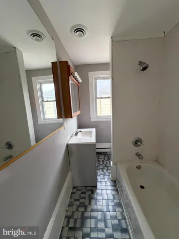 a bathroom with a bathtub sink and mirror