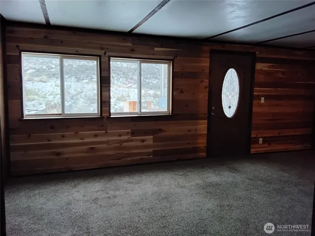 a view of an empty room with cabinet and a window