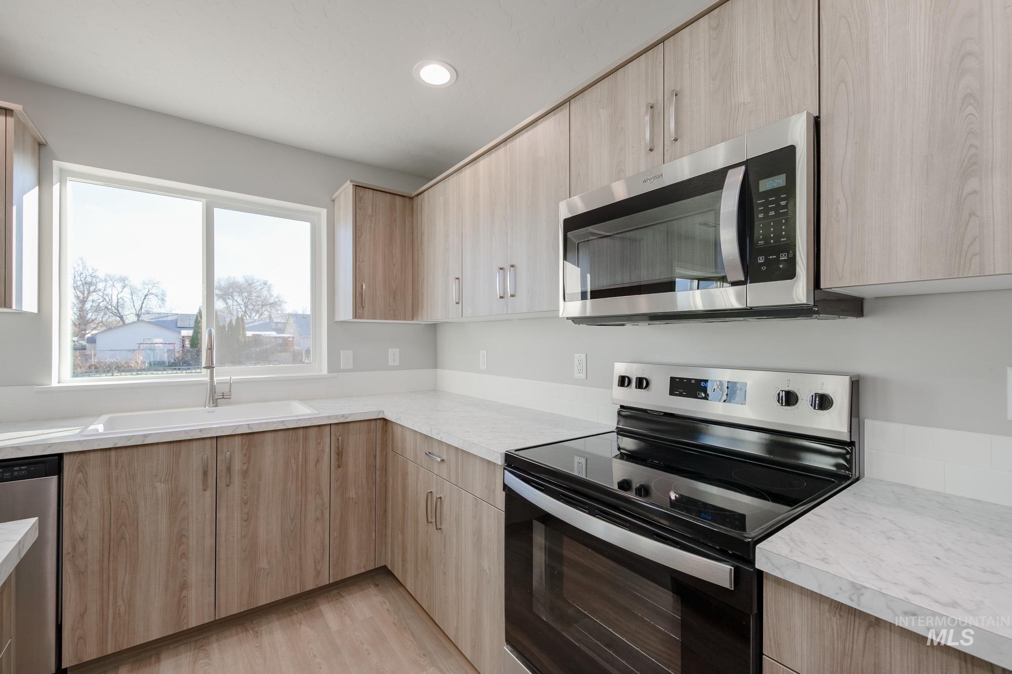 3210 South Maple Rnch Way Nampa, ID 83686 - Photo 11 of 22 Kitchen with stainless steel appliances, light countertops, light brown cabinetry, light wood-style floors, and recessed lighting