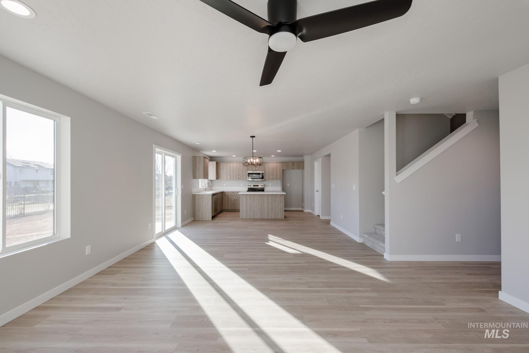 3210 South Maple Rnch Way Nampa, ID 83686 - Photo 12 of 22 Unfurnished living room featuring recessed lighting, light wood-type flooring, ceiling fan, and stairs