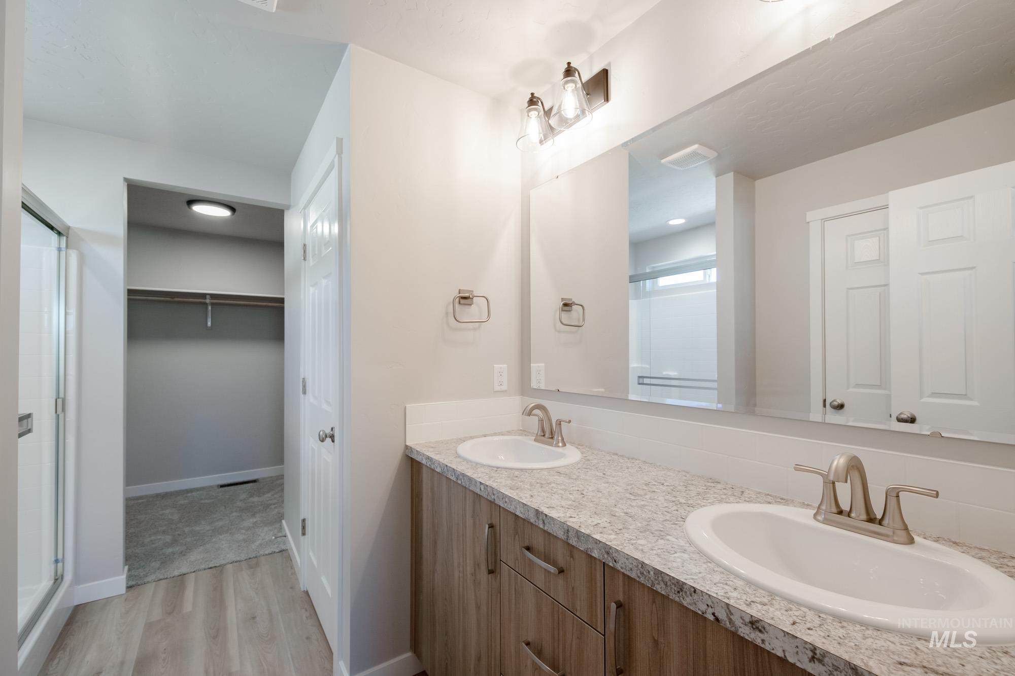 3210 South Maple Rnch Way Nampa, ID 83686 - Photo 14 of 22 Bathroom featuring a spacious closet, a shower stall, double vanity, and light wood finished floors