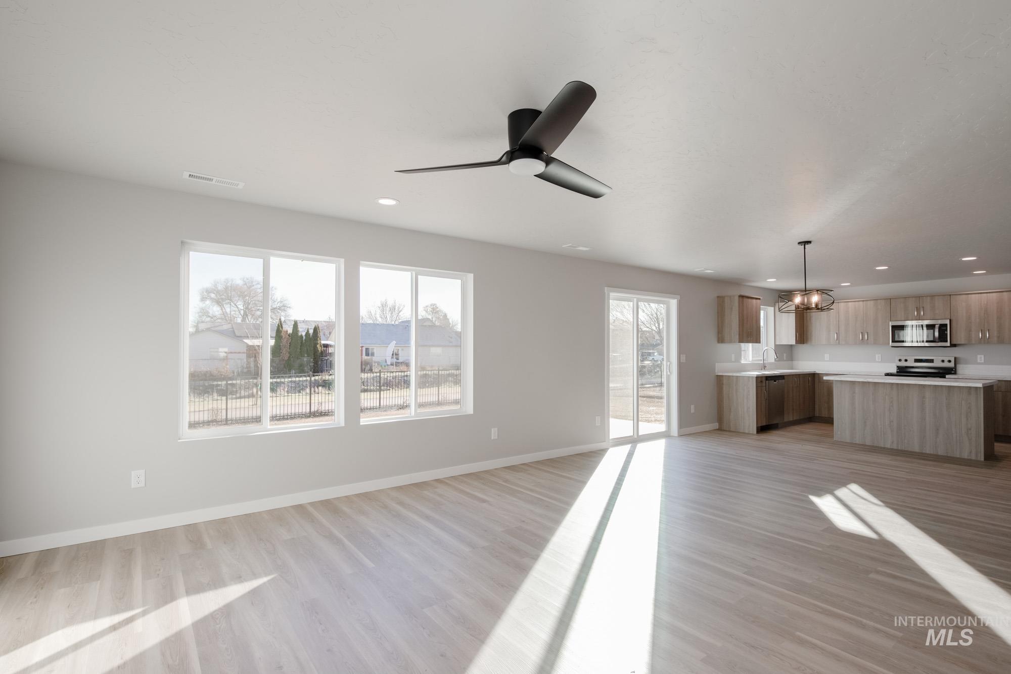 3210 South Maple Rnch Way Nampa, ID 83686 - Photo 5 of 22 Unfurnished living room featuring a chandelier, light wood-type flooring, recessed lighting, and a ceiling fan