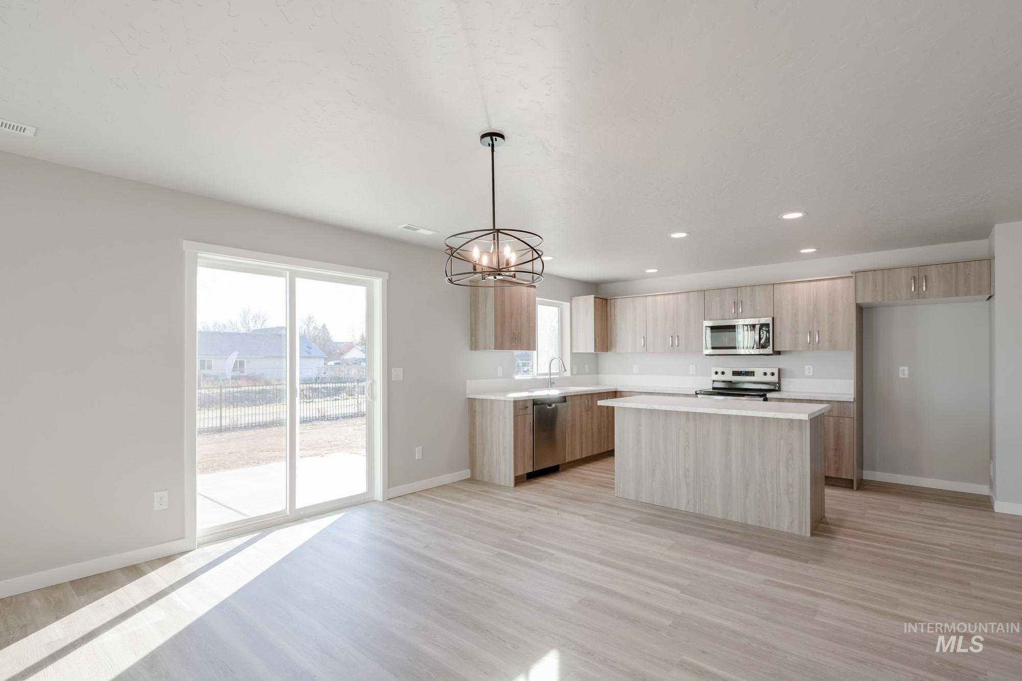 3210 South Maple Rnch Way Nampa, ID 83686 - Photo 7 of 22 Kitchen with a chandelier, modern cabinets, recessed lighting, a center island, and pendant lighting