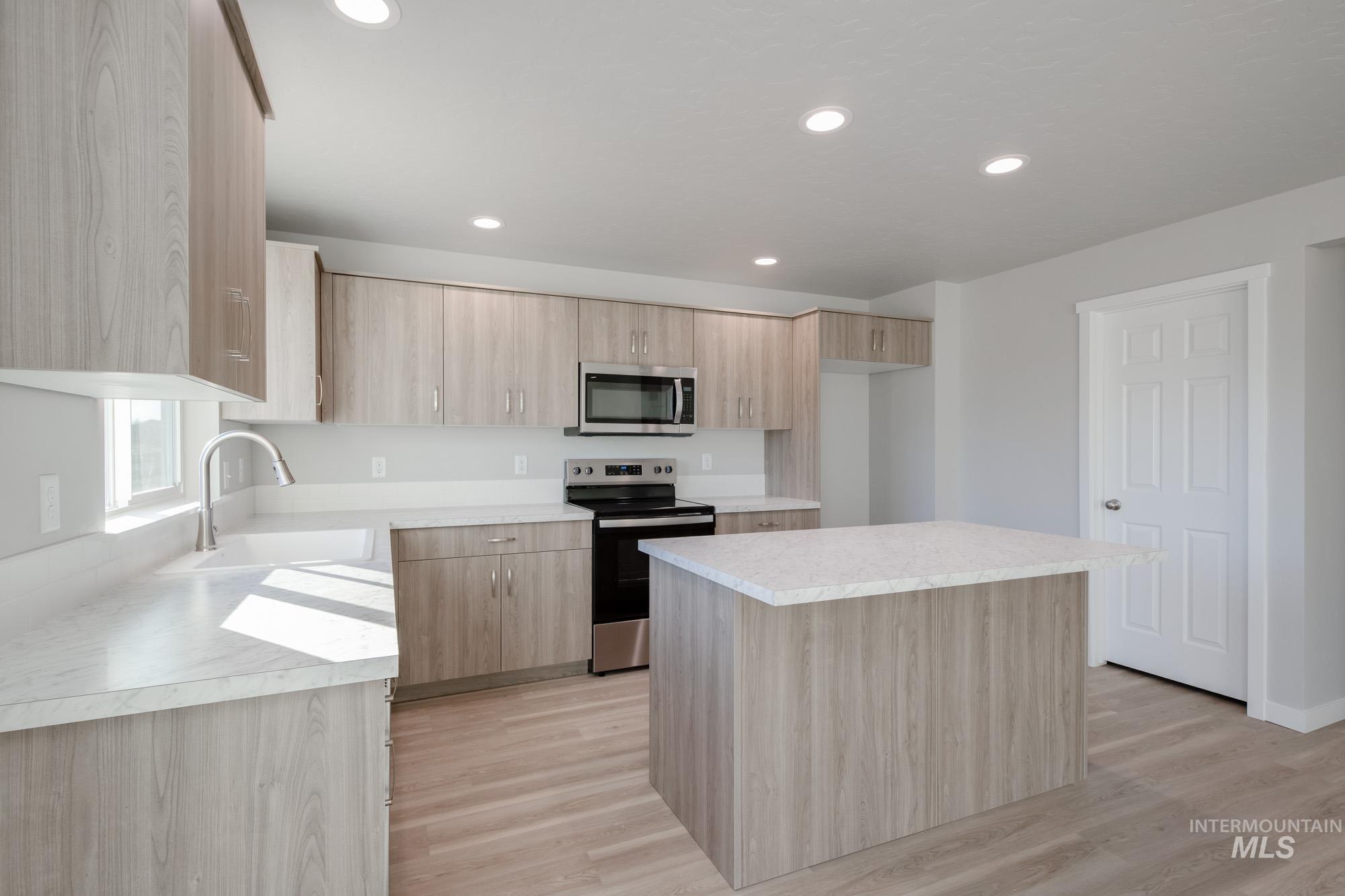 3210 South Maple Rnch Way Nampa, ID 83686 - Photo 10 of 22 Kitchen with stainless steel appliances, light brown cabinetry, a center island, light countertops, and recessed lighting