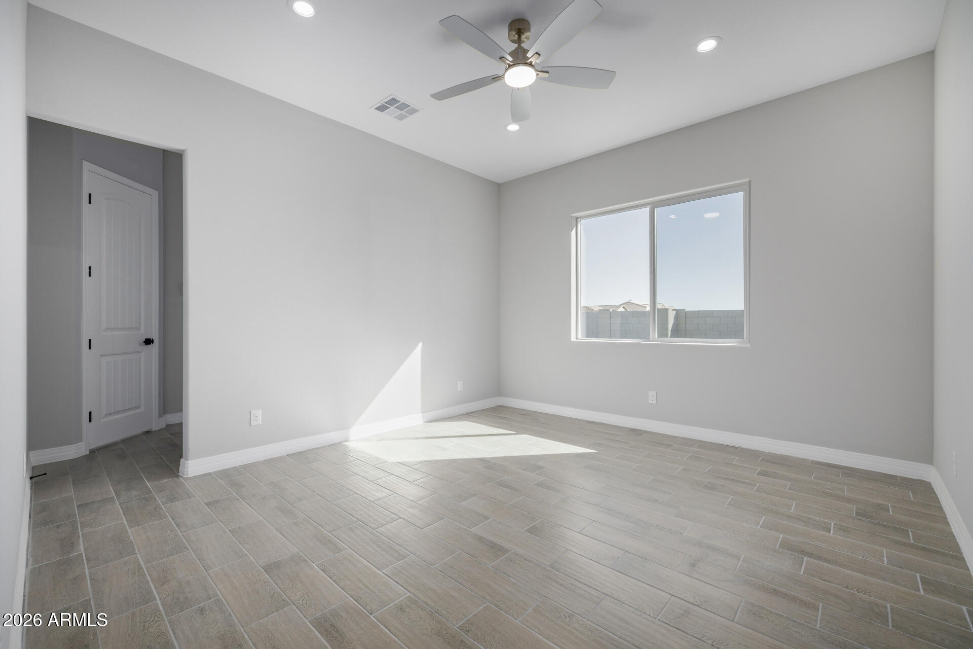 14099 South Vera Cruz Road Arizona City, AZ 85123 - Photo 13 of 32 wooden floor in an empty room with a window