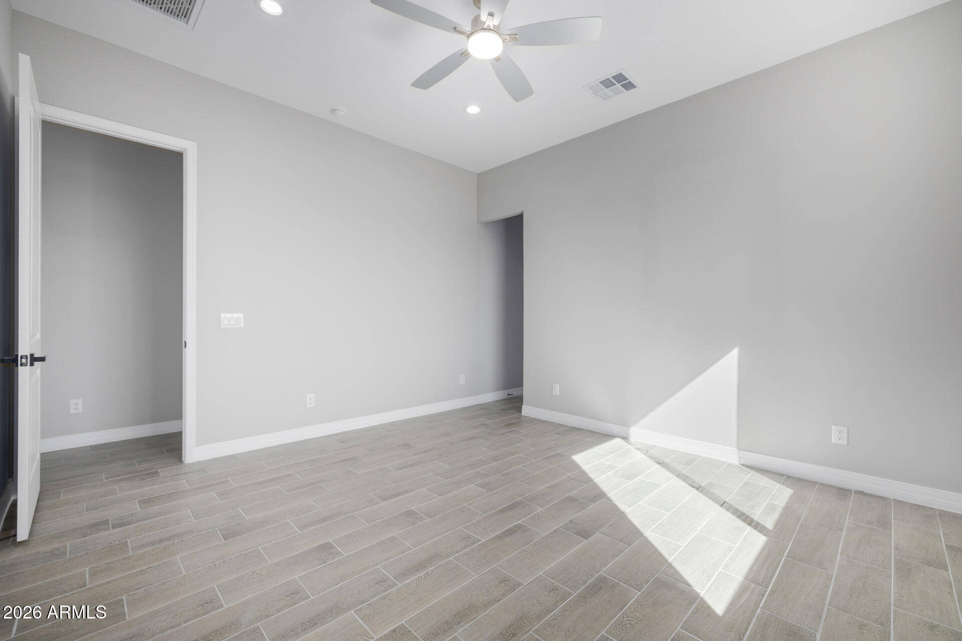 14099 South Vera Cruz Road Arizona City, AZ 85123 - Photo 14 of 32 an empty room with wooden floor and ceiling fan