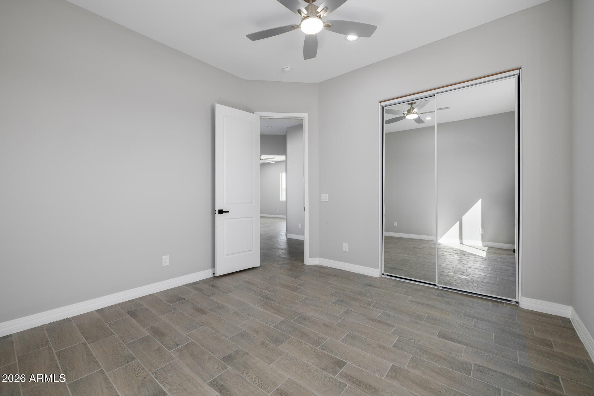 14099 South Vera Cruz Road Arizona City, AZ 85123 - Photo 23 of 32 an empty room with wooden floor fan and windows