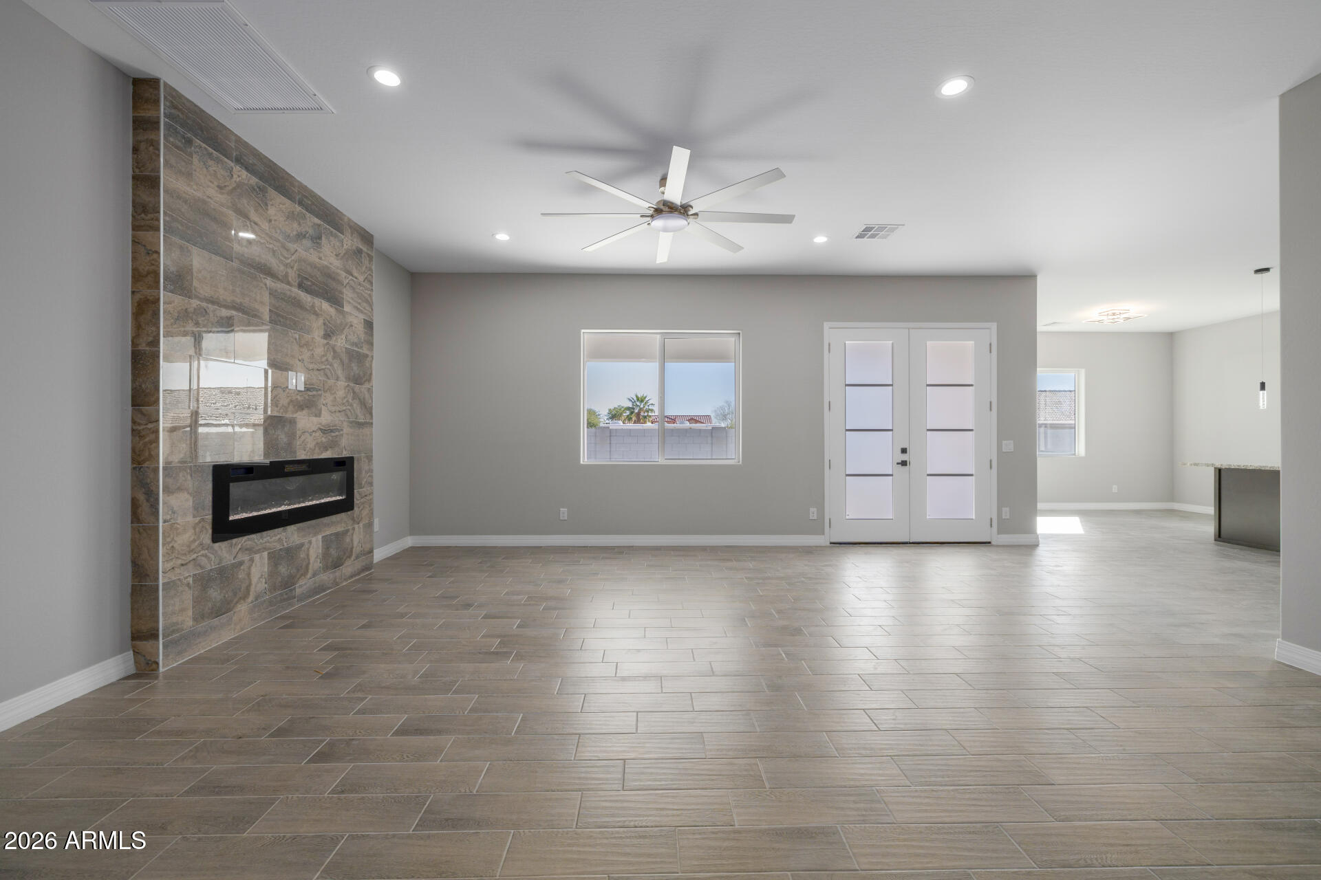 14099 South Vera Cruz Road Arizona City, AZ 85123 - Photo 4 of 32 an empty room with wooden floor and windows