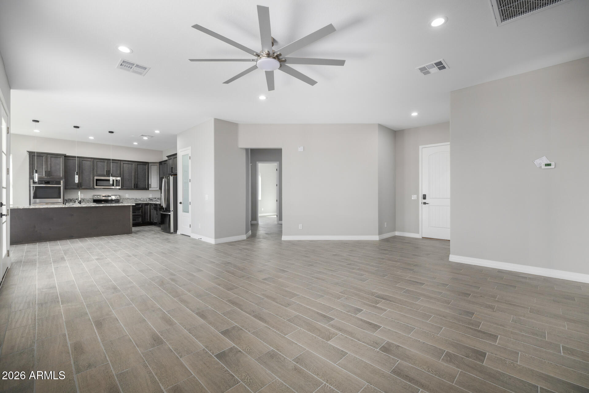 14099 South Vera Cruz Road Arizona City, AZ 85123 - Photo 6 of 32 an empty room with wooden floor and windows