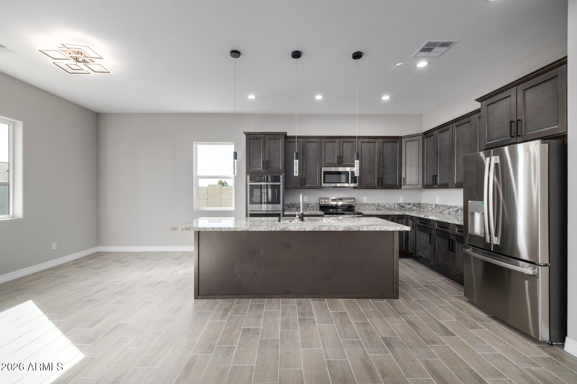14099 South Vera Cruz Road Arizona City, AZ 85123 - Photo 8 of 32 a kitchen with kitchen island granite countertop wooden floors stainless steel appliances a sink and a window