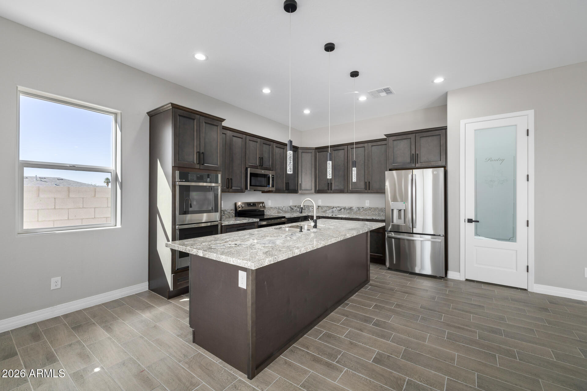 14099 South Vera Cruz Road Arizona City, AZ 85123 - Photo 9 of 32 a large kitchen with stainless steel appliances granite countertop a large counter top a stove a refrigerator and a sink