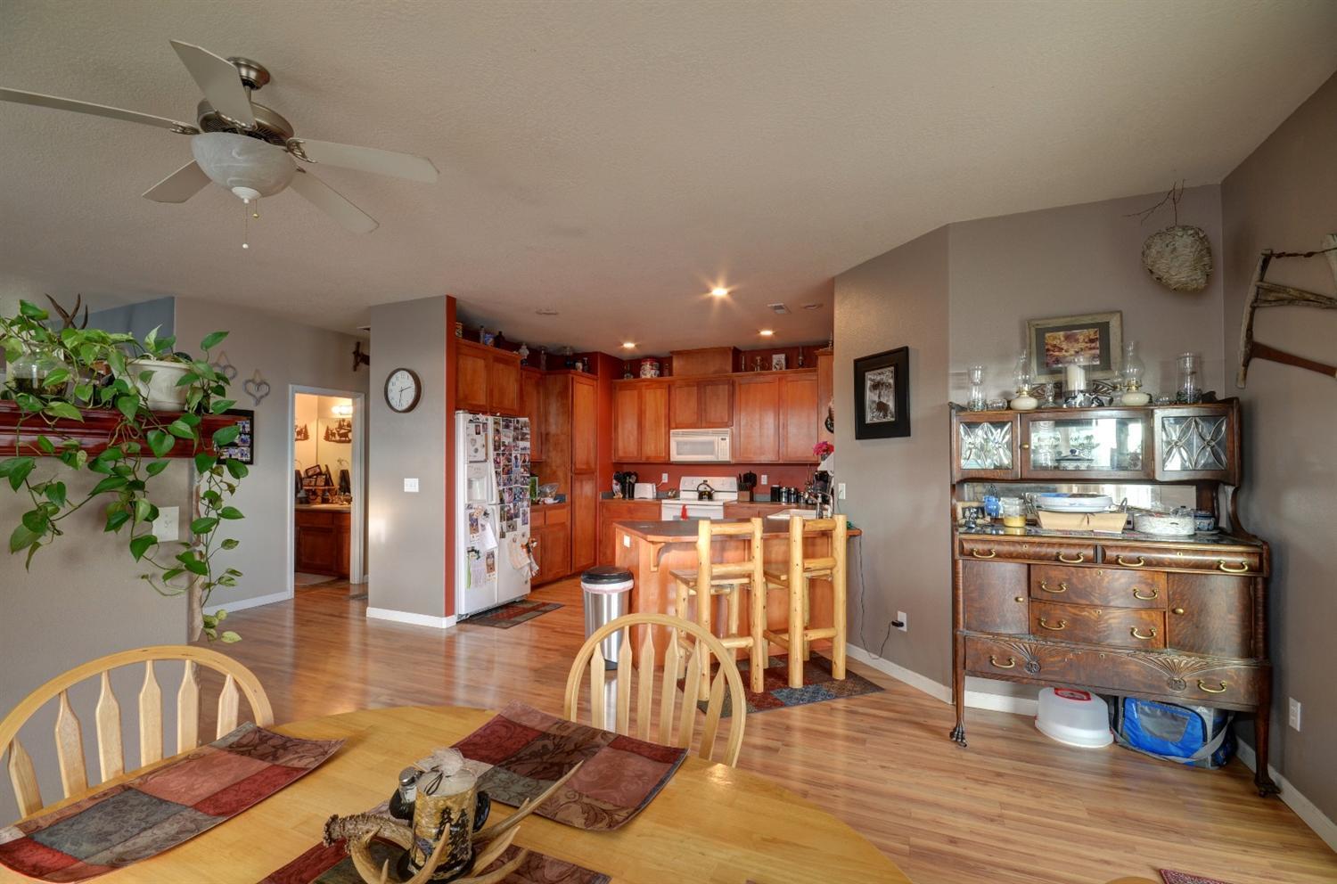 917 Ridgeview Drive Eagle Point, OR 97524 - Photo 11 of 31 a kitchen with stainless steel appliances kitchen island granite countertop a refrigerator a stove top oven a dining table and chairs with wooden floor