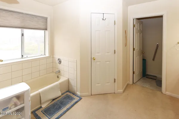 a bathroom with a tub a window and a shower