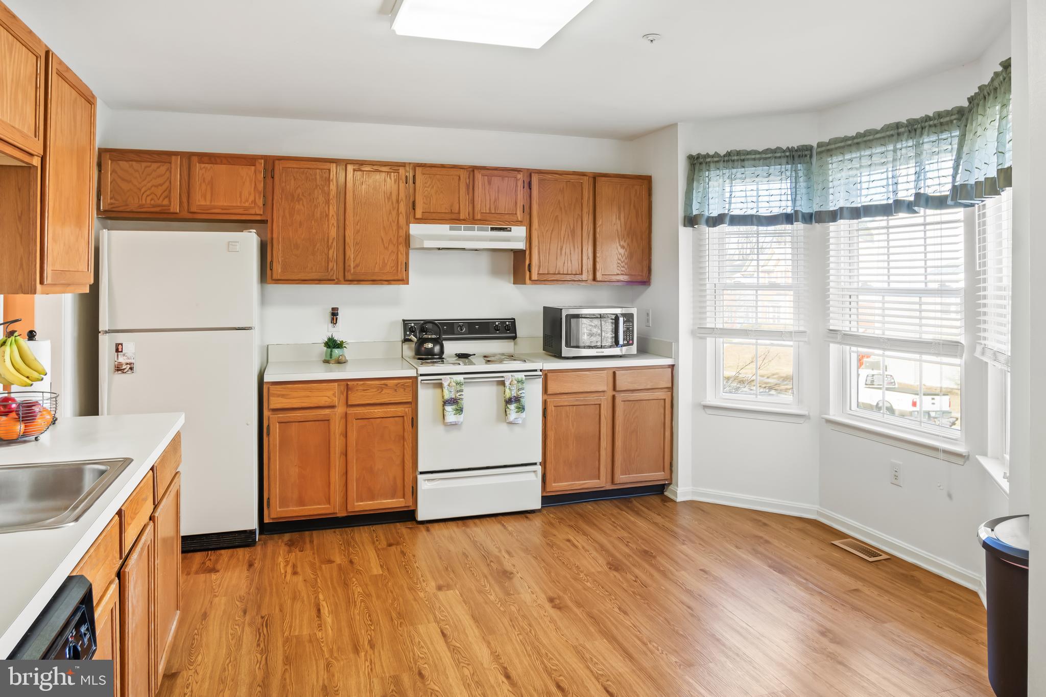2230 Conquest Way Odenton, MD 21113 - Photo 18 of 47 a kitchen with stainless steel appliances a sink cabinets and wooden floor