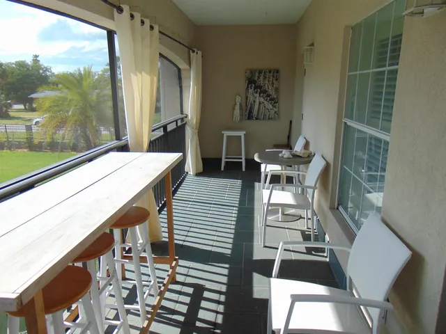 a dining room with furniture and a floor to ceiling window