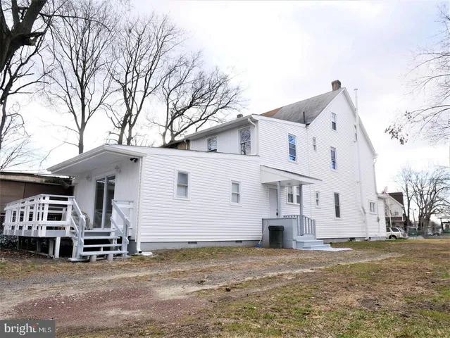 a view of a white house with a large tree and a yard