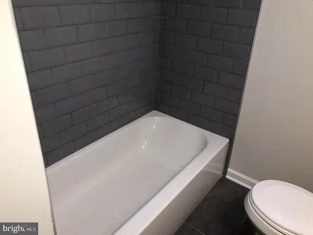 a bathroom with a white toilet and a bathtub