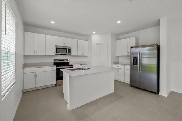 a kitchen with white cabinets and stainless steel appliances