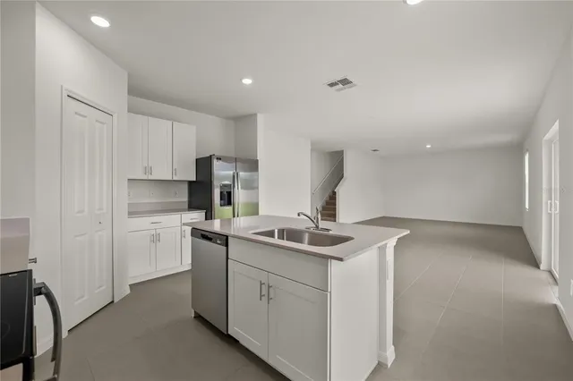 a kitchen with a sink and steel appliances