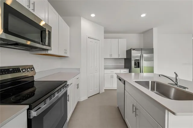 a kitchen with stainless steel appliances a refrigerator sink and microwave