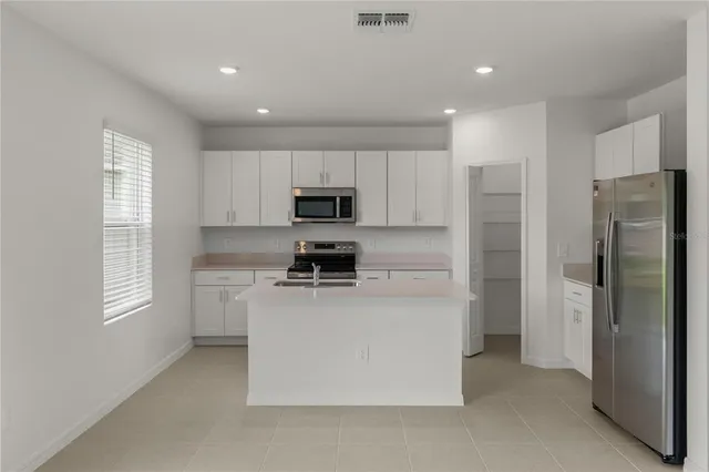 a kitchen with stainless steel appliances a refrigerator sink and microwave