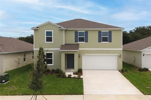 a front view of a house with a yard and garage