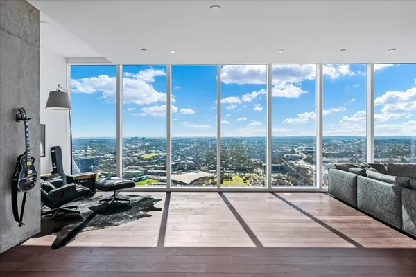 a view of a living room with furniture and floor to ceiling window