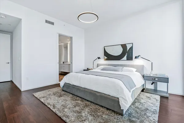 a bedroom with a bed and wooden floor