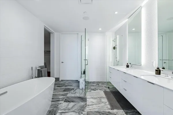 a bathroom with a tub sink and mirror