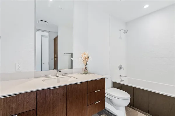 a bathroom with a sink vanity mirror and toilet