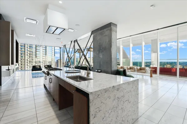 a large kitchen with kitchen island a large window a sink and stainless steel appliances