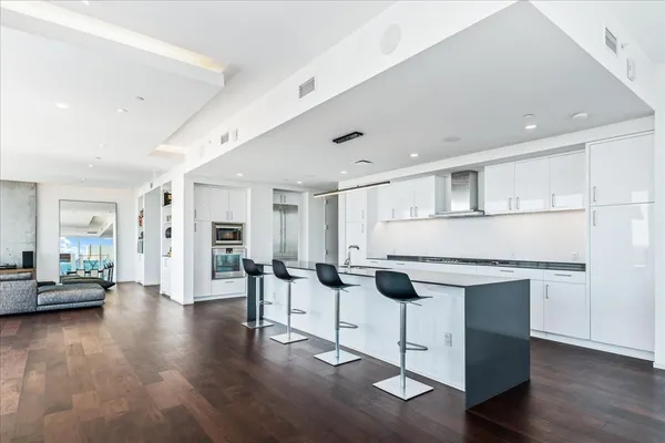 a kitchen with cabinets and wooden floor