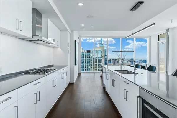 a large white kitchen with a sink and cabinets