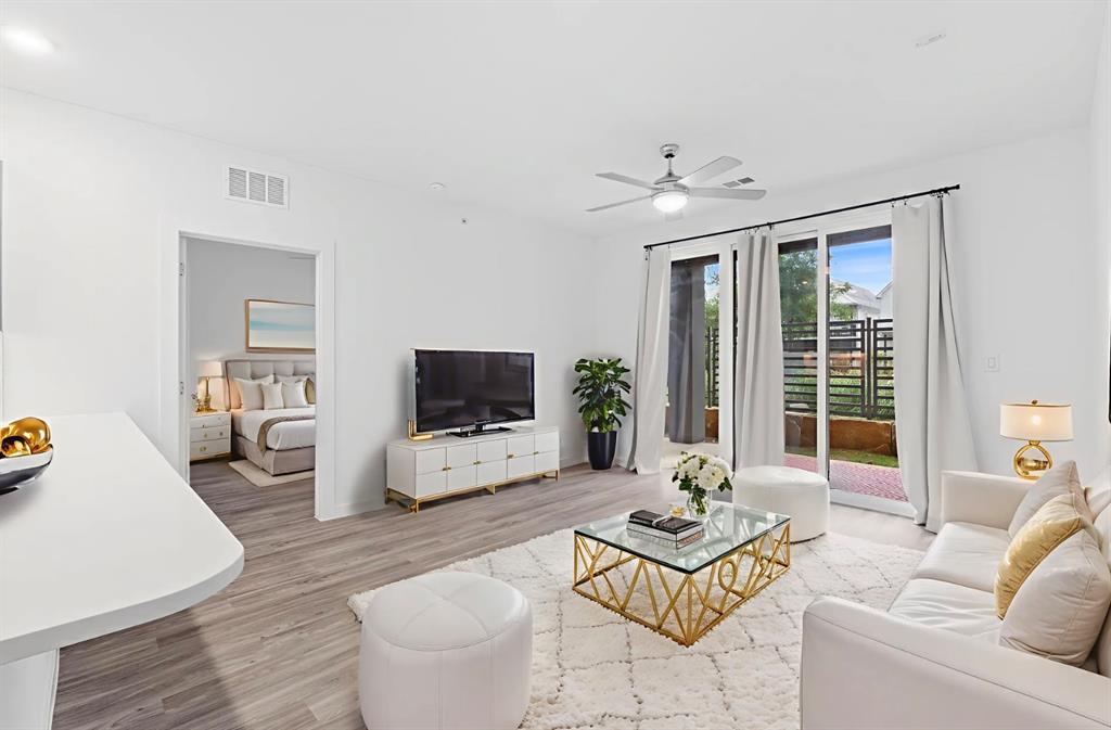 Living area with light wood-type flooring and a ceiling fan