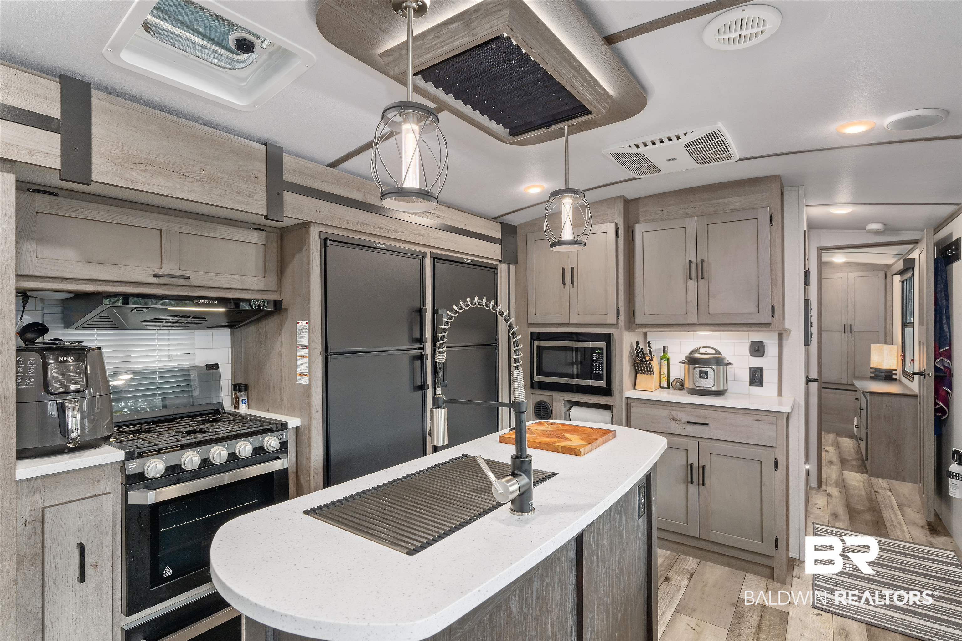 683 Escambia Loop Lillian, AL 36549 - Photo 7 of 27 Kitchen featuring light hardwood / wood-style flooring, an island with sink, appliances with stainless steel finishes, tasteful backsplash, and decorative light fixtures