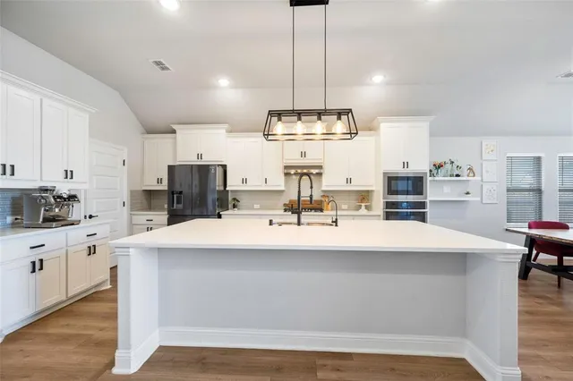 a large kitchen with kitchen island a large island in the center and stainless steel appliances