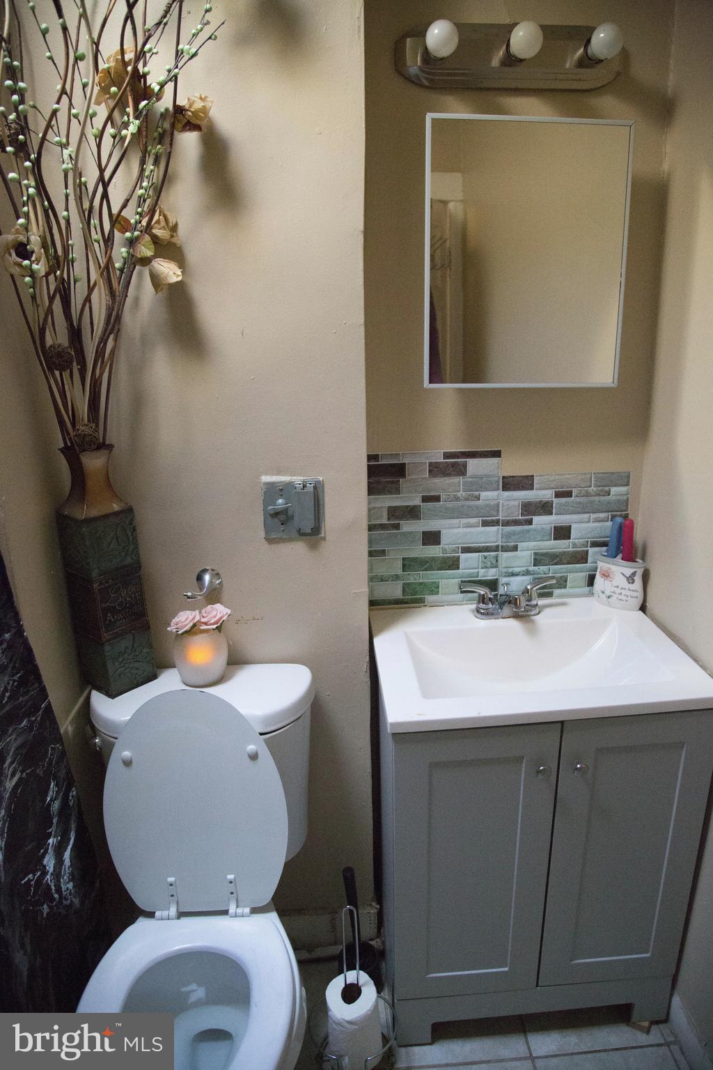 1708 Normal Avenue Baltimore, MD 21213 - Photo 6 of 18 a bathroom with a sink toilet and mirror