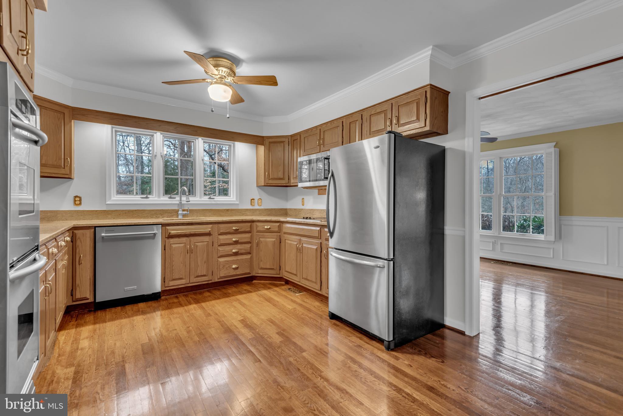 671 Discovery Court Davidsonville, MD 21035 - Photo 32 of 71 a kitchen with a refrigerator a sink and dishwasher with wooden floor