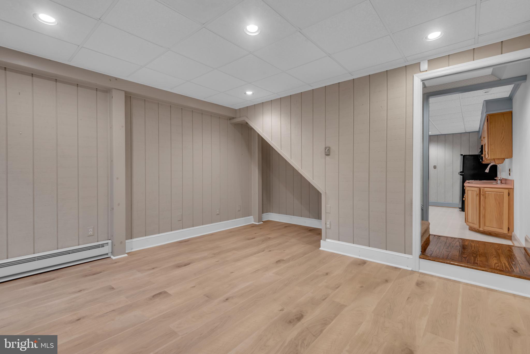671 Discovery Court Davidsonville, MD 21035 - Photo 56 of 71 a view of an empty room with wooden floor and a kitchen