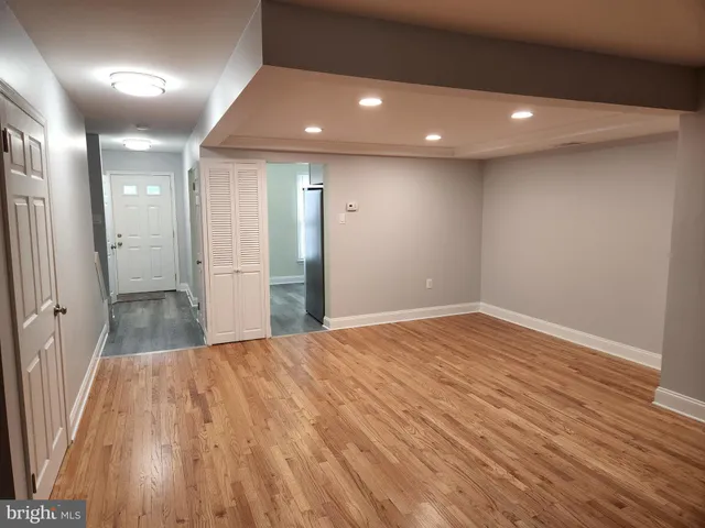 a view of empty room with wooden floor