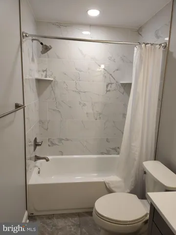 a bathroom with a toilet and a bathtub