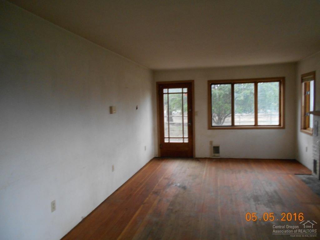 23045 Alfalfa Market Road Bend, OR 97701 - Photo 4 of 12 an empty room with wooden floor and windows