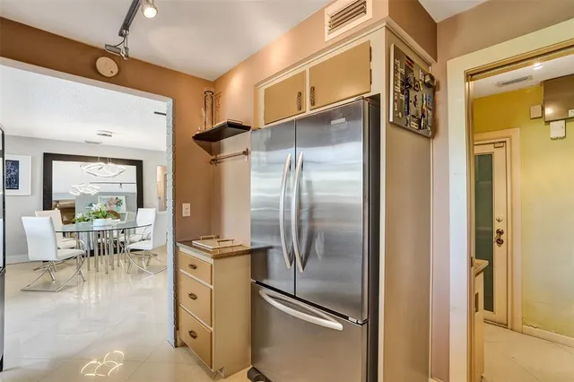 a kitchen with stainless steel appliances a refrigerator and a dining table